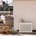 Cache clim gris anthracite (RAL 7016) Cabanaclim – – posé dans un environnement extérieur aménagé. Idéal pour dissimuler une unité extérieure dans un espace déco avec plantes, mobilier outdoor et ambiance architecturale.